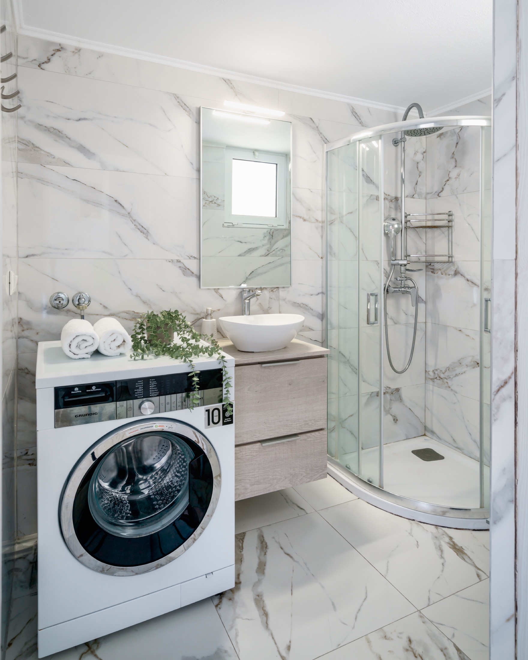 Modern bathroom with shower and washing machine